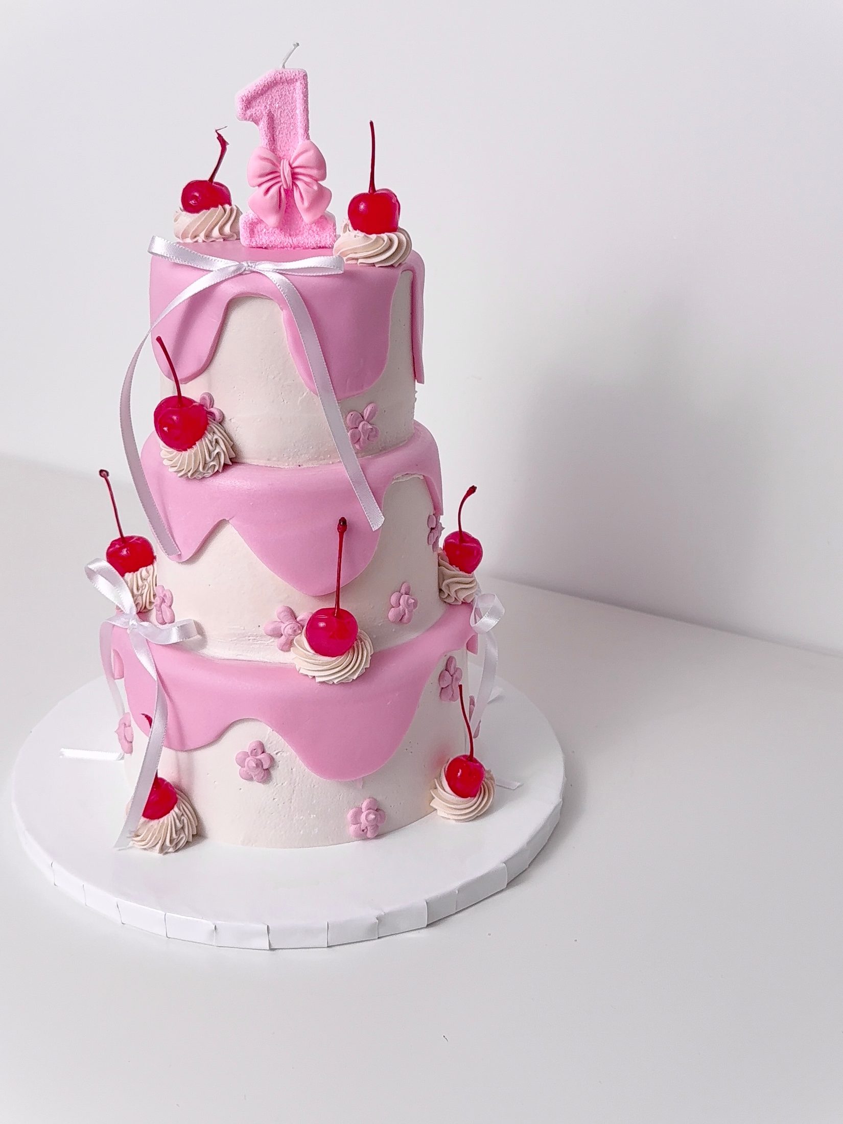 Pink first birthday cake with cherries